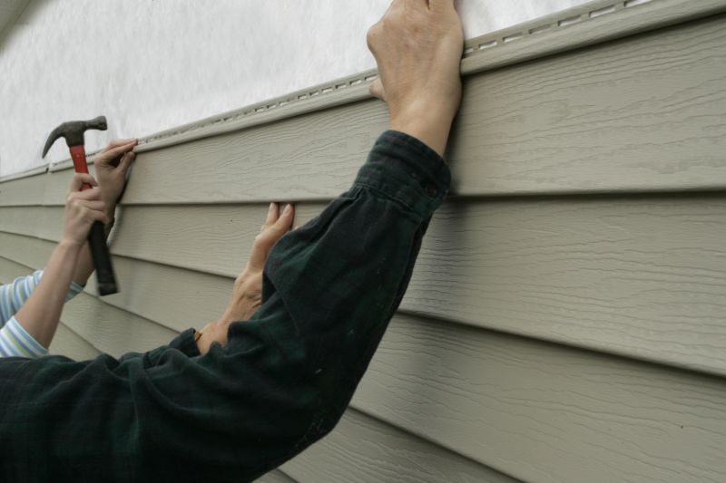 Siding panels being aligned on a home exterior